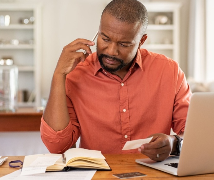 a man on his mobile phone reviewing paperwork