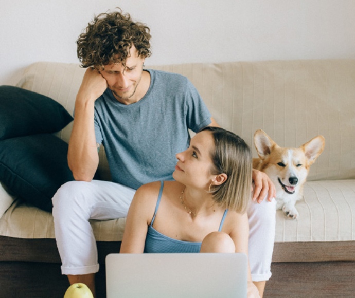 a couple and their dog sitting on a couch